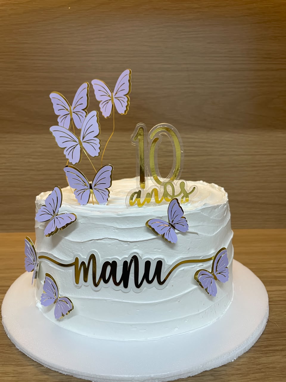 Bolo branco com borboletas lilás e topper "manu 10 anos"