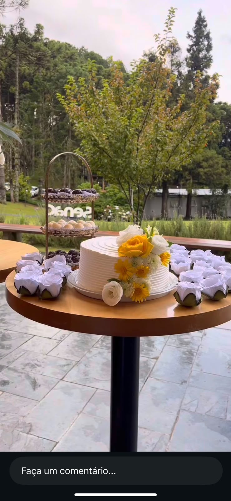 Bolo branco com flores amarelas e brancas naturais em mesa de evento