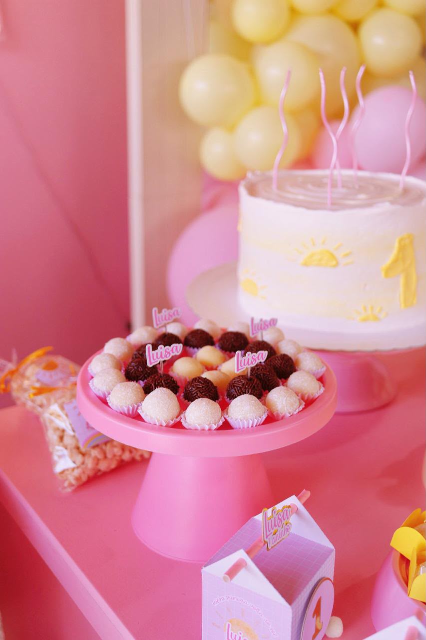 Mesa de festa rosa com bolo tema sol e docinhos personalizados